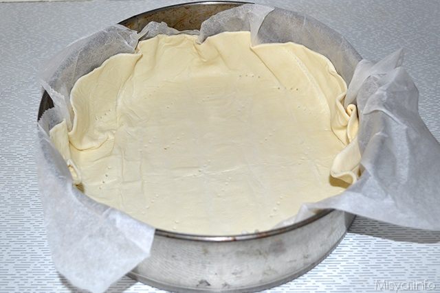 foderare una teclgia con la carta da forno e rivestire con uno strato di pasta sfoglia